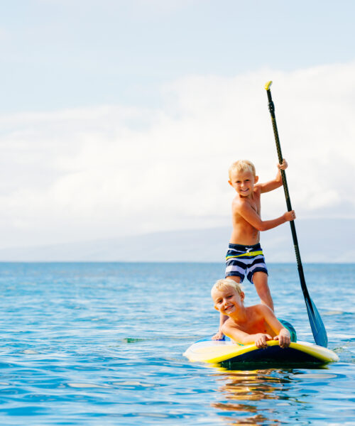 children having fun on paddle board