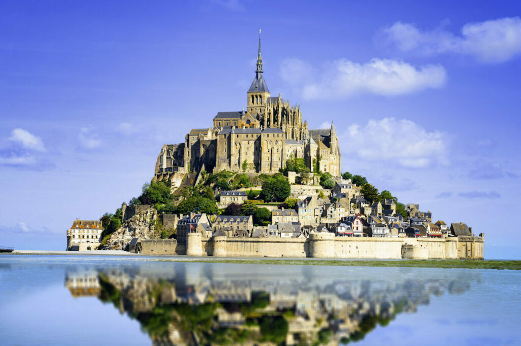 Historic Mont Saint-Michel in Normandy, France, featuring the renowned medieval abbey rising above tidal waters, symbolizing centuries of French history and architectural heritage.