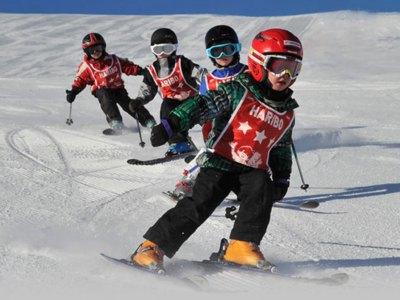 Kids skiing down a slope following each other