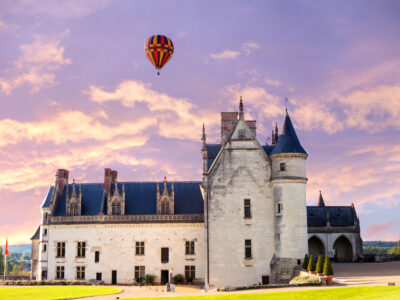 hot air balloon hovering over a chateau in the Loire Valley